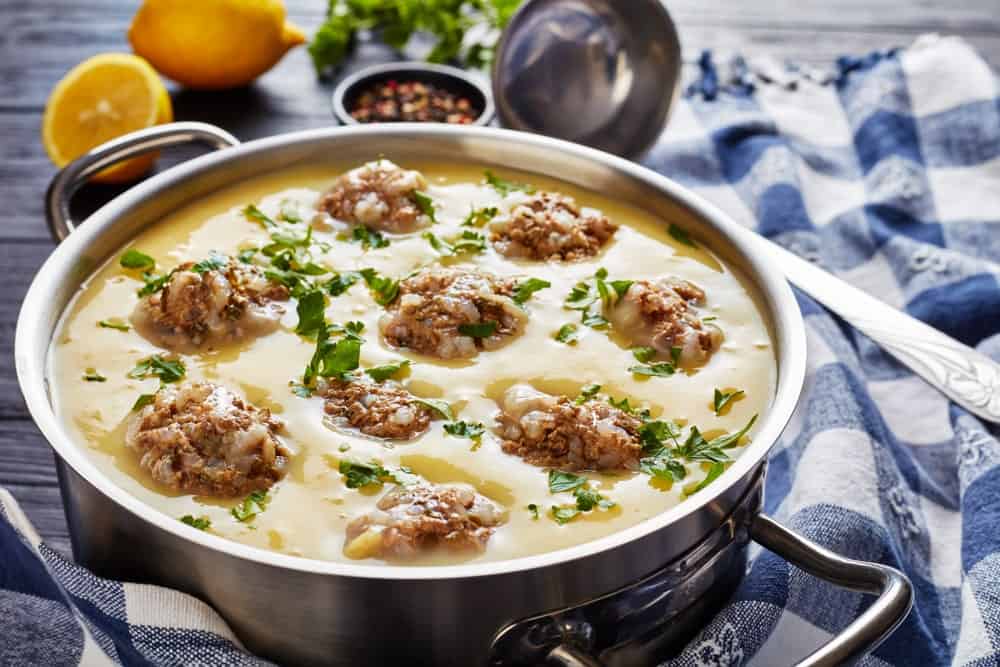 hearty Greek Meatball Soup - Giouvarlakia, Youvarlakia in Egg lemon sauce in a metal casserole